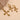 This image displays a set of elegant crucifix necklace and earrings. The pieces are crafted in a shimmering gold-tone metal, embellished with multiple clear stones that add a subtle sparkle.