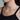 A woman wearing a silver dainty necklace chain.
