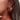 Gold hoop earrings worn by a person with brown hair.