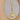 A gold-colored pendant in the shape of a sun with a circular design, displayed on a reflective surface.