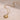 A gold-colored pendant necklace with a sun and moon design, featuring small diamonds