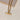 Gold necklace with a unique pendant on a light beige background