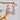 Gold heart-shaped earrings hanging on a branch with a blurred background