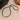 A green bead necklace with a freshwater pearl, displayed against a neutral background with a rock and a shadow.