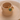 Gold ring with a green stone on a beige ceramic stand