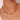 Gold chain necklace worn by a person against a neutral background