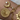 Gold bracelet with moon, coin, and sun charms on a wrist.