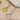 Two necklaces with star designs on a beige surface