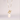 A gold-colored necklace with a t-bar closure and a large freshwater pearl pendant, accompanied by small faux pearls on the chain.