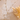 Gold necklace with pearls on a textured beige surface