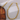 Gold chain necklace on a textured surface with wooden block