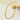 Gold necklace with small stones on a light beige background