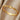 Gold braided ring on a beige fabric background