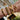 Gold bracelets on a wrist with a blurred indoor background