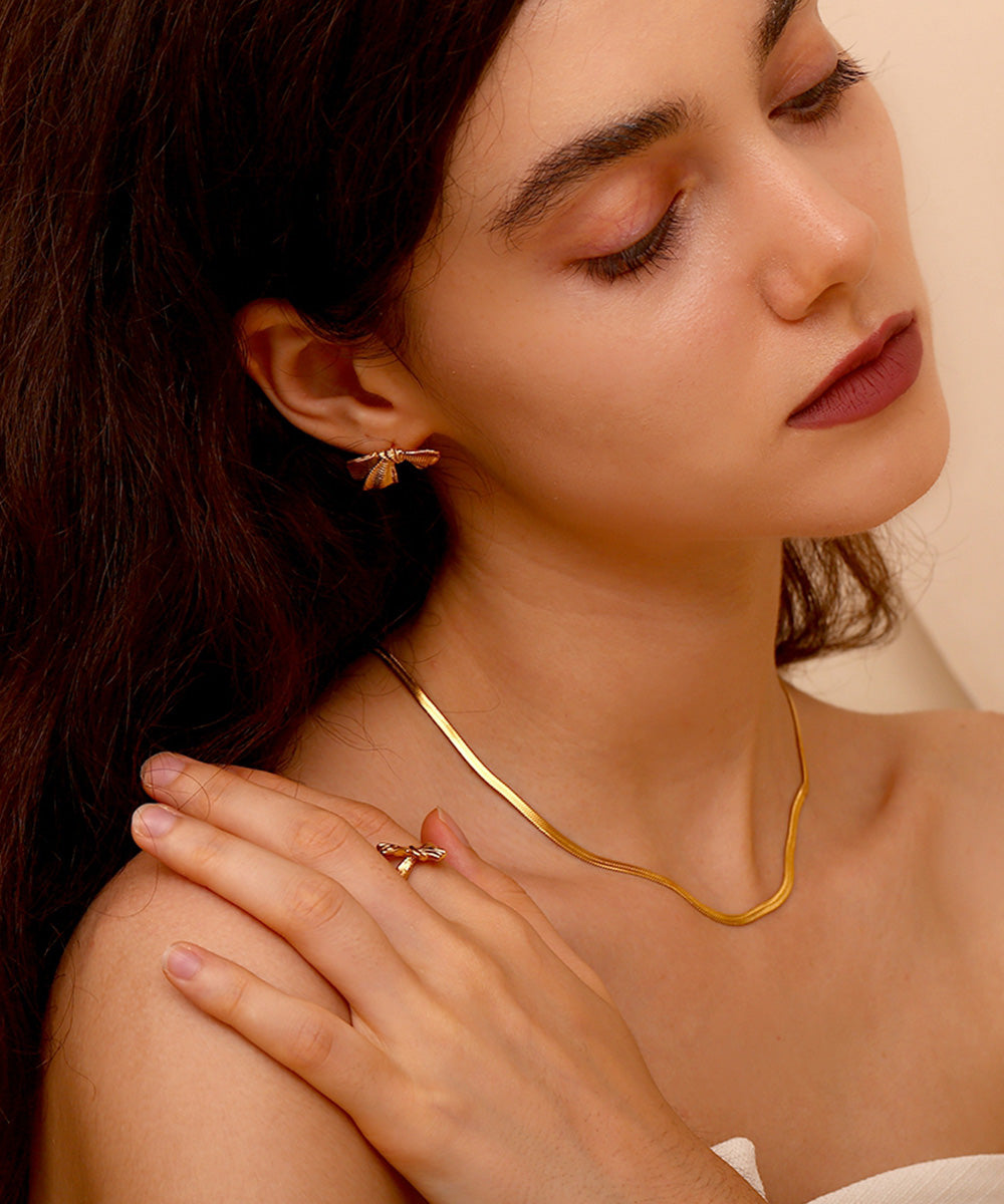 Woman with brown hair wearing gold jewellery