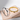 Two gold and silver rings on a textured surface with a light gray background
