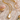 Gold necklace with a large pearl pendant on a textured surface