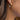 Close-up of a person wearing gold and silver hoop earrings.