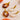 Pair of earrings with tortoiseshell and gold accents on a textured beige surface.