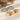 Three rings, two gold and one silver, with gemstones on a textured beige surface.