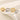 Four rings in gold and silver on a textured white surface