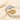 Two gold necklaces with intricate designs on a beige stone surface