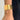 Gold textured cuff bracelet on a wrist with a neutral background