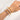Hand wearing three bracelets on a plain background