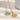 Two necklaces, one gold and one silver, on a light surface.