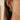 Gold and silver hoop earring worn by a person with a neutral background