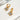 Gold hoop earrings with heart-shaped pendants on a white surface
