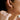 Close-up of a person wearing a gold hoop earring.