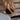 Hand with gold rings holding a coffee cup lid, with a blurred background