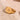 Gold ring with star design on a beige stone surface