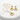 Gold necklace and earrings with green stones on a marble surface