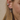 Close-up of a person wearing silver hoop earrings with a neutral background