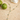 Gold necklace with turquoise stones on a sandy surface with green apples and a shell.