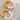 Pearl hoop earrings with gold clasps on a textured surface