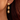 Gold earrings worn by a person with dark hair.