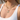 Close-up of a woman wearing a gold necklace with turquoise beads and a star-shaped pendant.