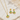 Gold jewelry set with green stones on a textured surface