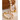 A beaded necklace and matching bracelet made of round cream-colored marbled beads with shiny gold spacer accents, styled on a light textured surface next to a large brown rock.