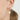 Gold fish-shaped earring with a pearl charm worn by a person.