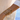 Gold bracelets on a wrist with a blurred background