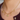 Gold necklace with various charms worn by a person