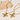 Gold cross-shaped pendant necklace with a green gemstone on a light background