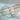 Gold chain necklaces with heart-shaped pendants on a light blue background