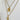 Gold necklace with pendant on a white stand
