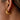 Gold hoop earring worn by a person