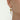 Gold star earring with pearl drop worn by a person on a white background